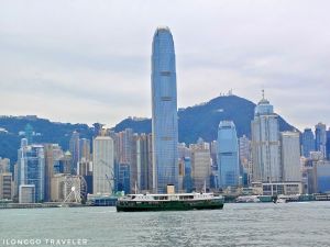 Hong Kong skyline view from Victoria Harbour with skyscrapers and ferry at sunset