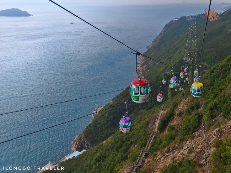 Ocean Park cable car gliding above South China Sea with verdant hills in the background at Hong Kong Ocean Park