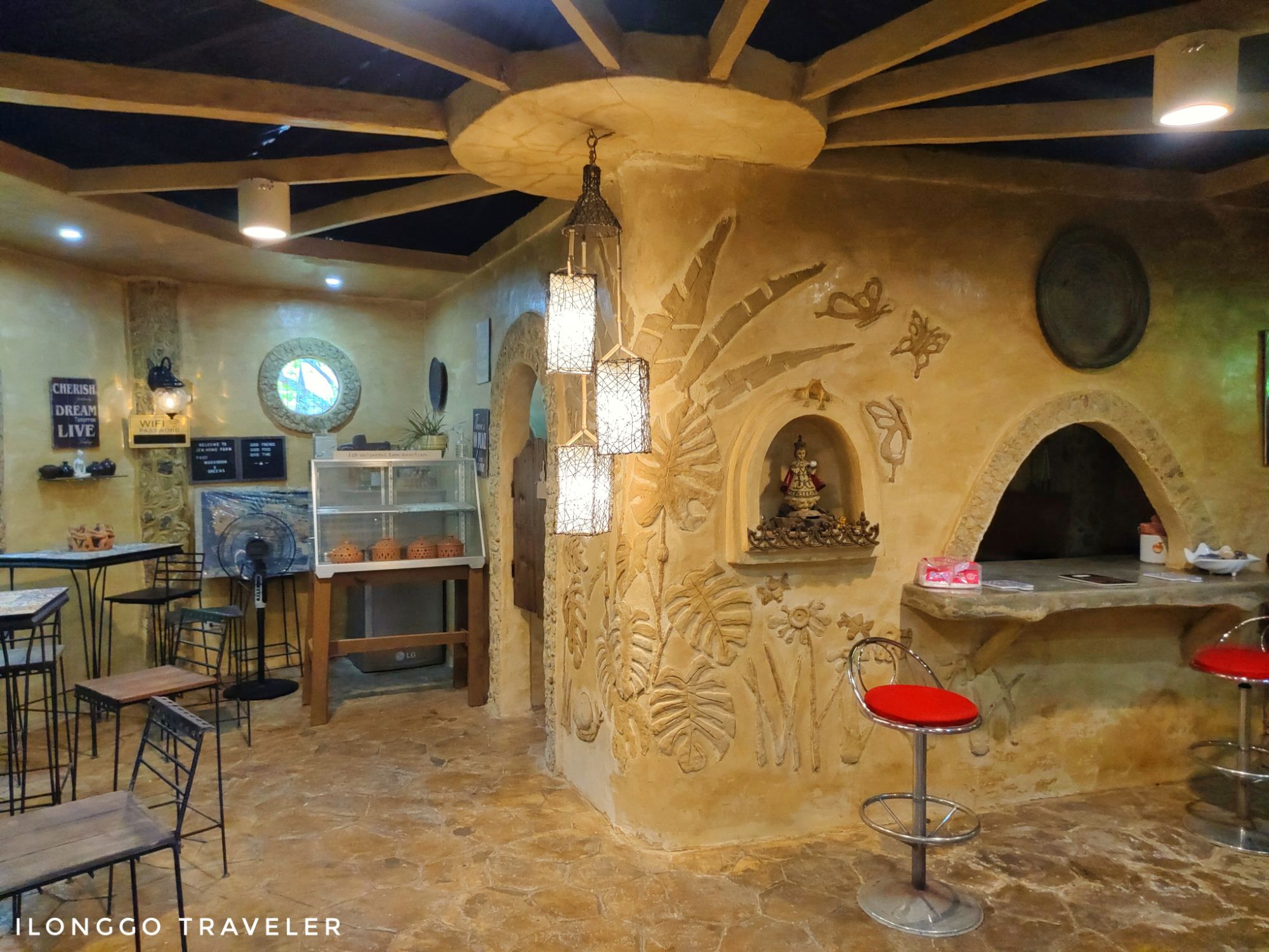 Interior of a hand-built mud house at Jem Home Farm in Sibunag, Guimaras, featuring earthen walls, bamboo beams, and natural ventilation design