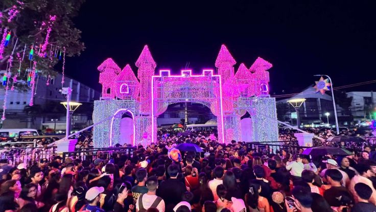 A large crowd gathers in front of the Iloilo Provincial Capitol at night as the building lights up with Christmas decorations during its official opening of lights on December 5, 2025.