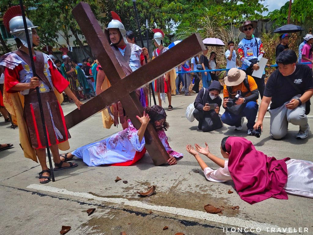 Woman offering water to Jesus Christ during the Way of the Cross reenactment at Taltal sa Barotac Viejo Iloilo