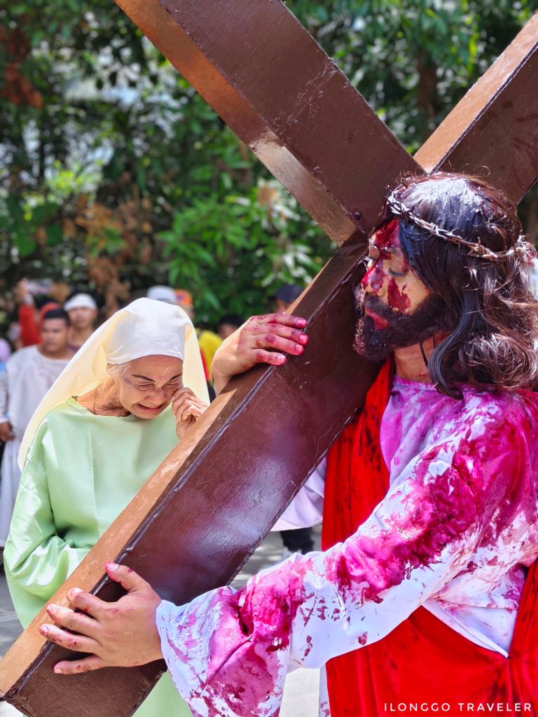 Jesus Christ carrying the cross as an elderly woman cries during Taltal sa Barotac Viejo Iloilo Good Friday reenactment